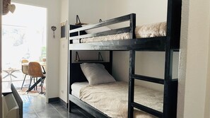 Ein Stockbett mit Schreibtisch und Stuhl in einem Zimmer.
