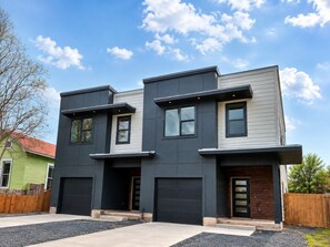 A modern two-story house with a garage, a front porch, and a driveway.