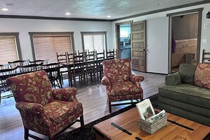 A spacious room with a dining area, two armchairs, a sofa, and a coffee table. - Serene 6-bedroom hotel suites with AC in Equinunk (Equinunk)