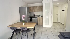 Una cocina moderna con comedor, refrigerador y cafetera.