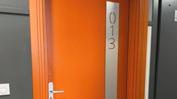 Puerta con placa metálica que indica el número de habitación 013.