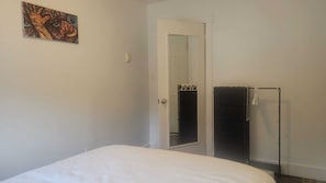 Un dormitorio con cama, armario y puerta que da a otra habitación.