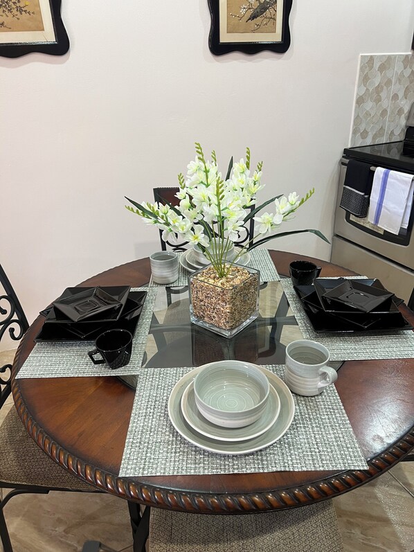 A dining table set with plates, cups, and a decorative centerpiece. - Island Escape Wonderful 2-bedroom apartment with AC in charming Kelly Village (Kelly Village)