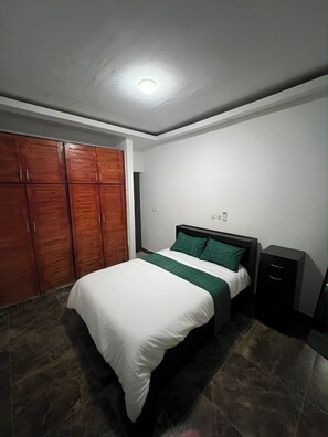 Ein Schlafzimmer mit Bett, Kleiderschrank und Schreibtisch.