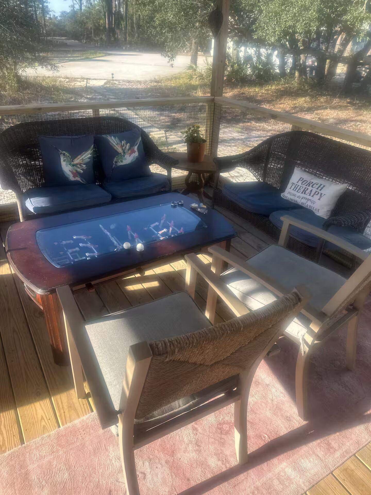 An outdoor seating area with wicker furniture, a table, and a view of the surrounding landscape.