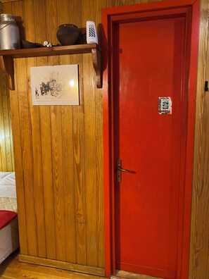 A wooden door with a red frame, a metal handle, and a small poster on the door. - La Tana della Marmotta. Close to village and ski lifts. Wooden loft (Champoluc)