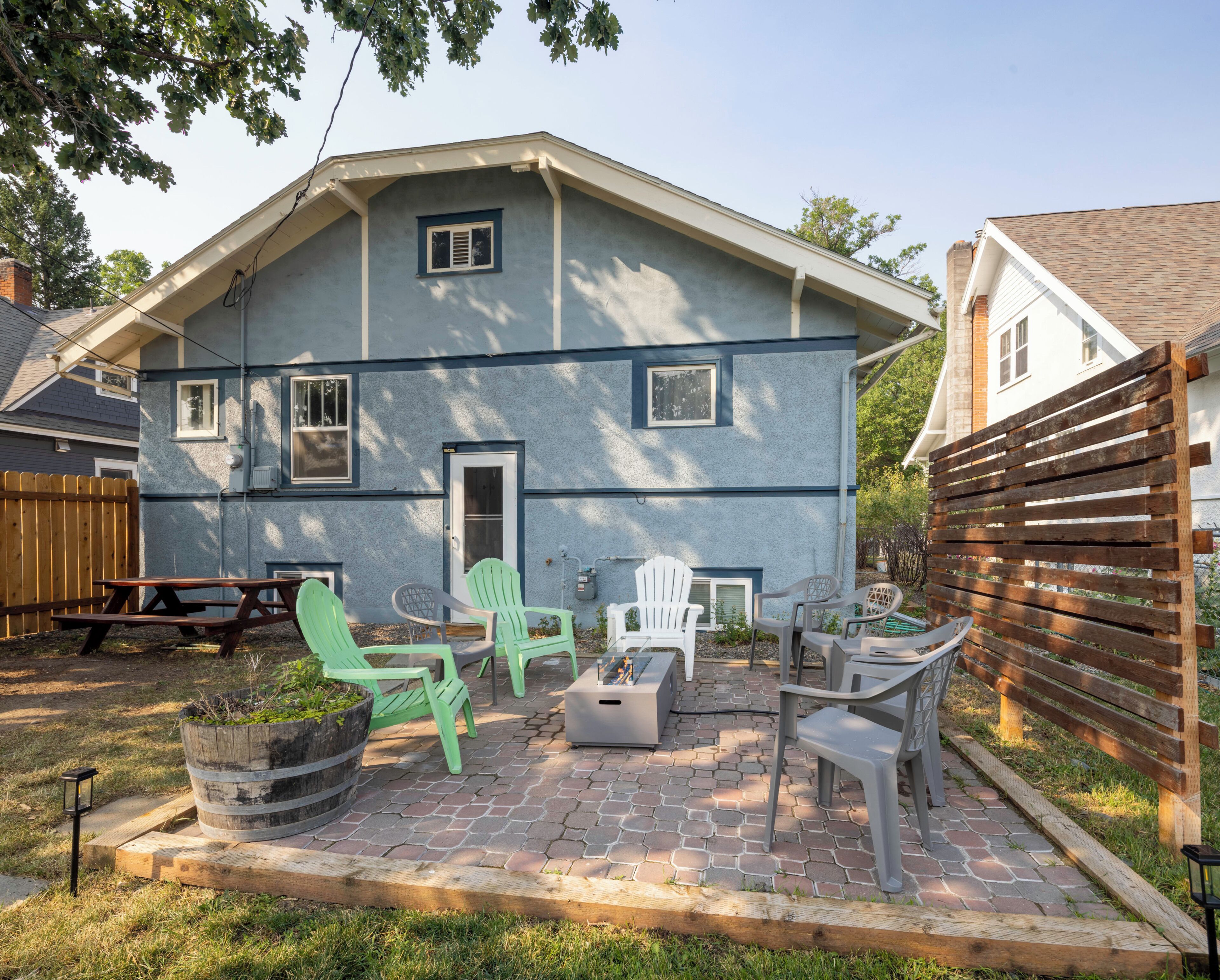 A house with a patio area featuring outdoor furniture and a fire pit.