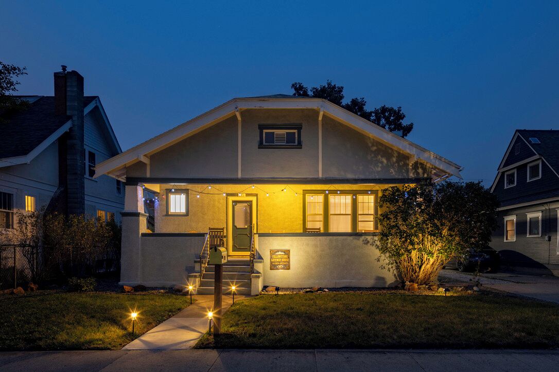 A two-story house with a front porch, a visible staircase, and a small front yard.