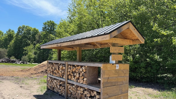 A wooden structure with a roof, labeled 'Firewood' and priced at $10 per cubic foot.