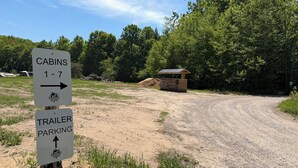 A sign indicating cabins 1-7 and trailer parking at Pinewood Cabins.