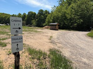 Un panneau indiquant l’emplacement des chalets numérotés de 1 à 7 et de l’aire de stationnement pour les remorques au Pinewood Cabins.