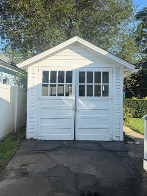 A white garage with two doors and a small overhang. - Adorable 2-bedroom Seasonal Rental in Milford Beach Neighborhood (Milford)