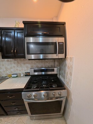 A kitchen with a stainless steel stove, oven, and microwave. - Julie Grove Peaceful 2-bedroom apartment with AC in charming Kelly Village (Kelly Village)