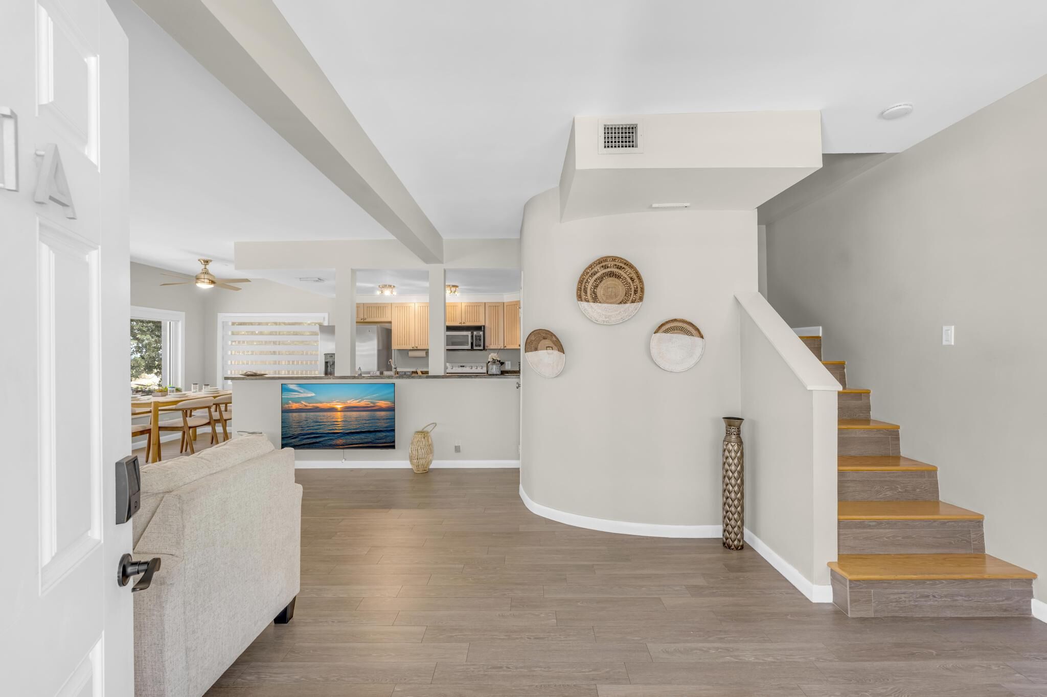 Un intérieur moderne comprenant une cuisine, un coin repas et un escalier.