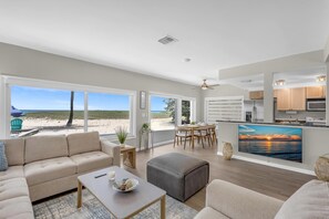 A spacious living area with a large window overlooking a beach, a dining area with a view, and a kitchen with modern appliances. - Pompano Beach + Townhouse + Private Beach + 3 bedroom + Pool = PERFECTION! (Pompano Beach)