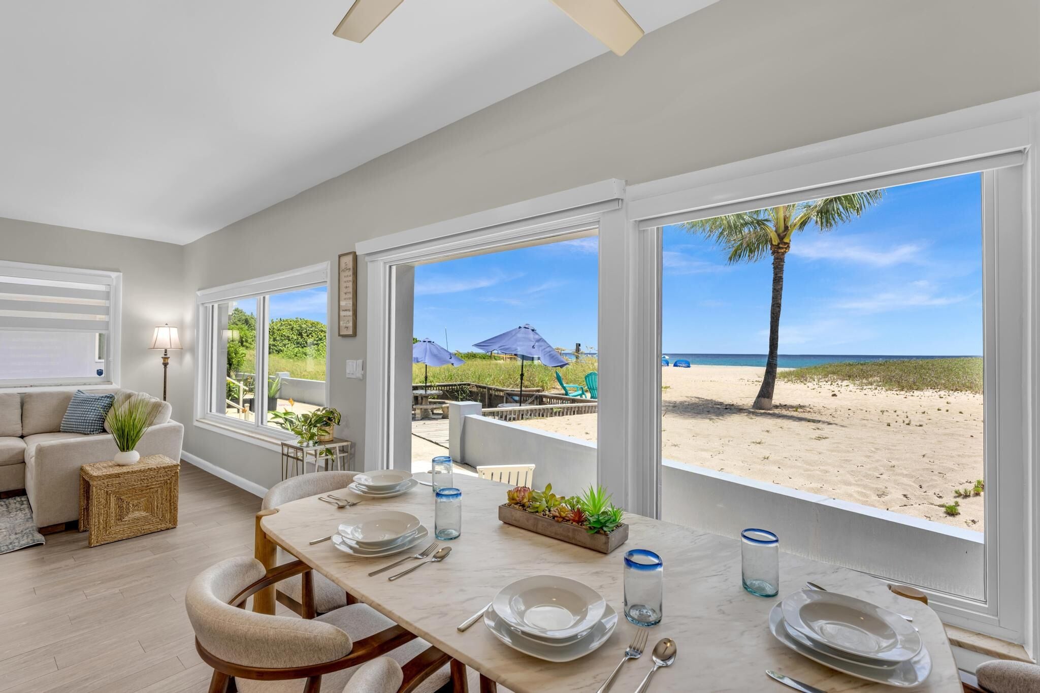 Un comedor con vista a la playa, un sofá y una lámpara.