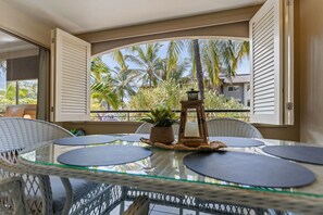 Ein Balkon mit Glastisch, Stühlen und einer Topfpflanze.