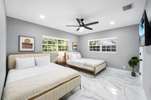 A hotel room with two beds, a ceiling fan, large windows, and a marble floor. - Mega-Yacht Showcase Villa with Pool Table/Marble (Fort Lauderdale)