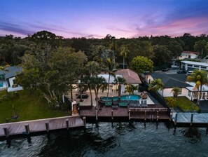 A waterfront property with a swimming pool, dock, and lush greenery. - Mega-Yacht Showcase Villa with Pool Table/Marble (Fort Lauderdale)