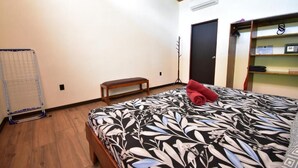 Une chambre à coucher avec un lit, un banc, une armoire et un radiateur.