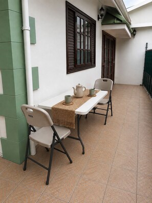A dining area with a table set for two, chairs, a teapot, and a cup. - Maison Teranga- 70m2, 2-BRM apartment, with AC, 5 minutes drive to Rodney Bay (Gros Islet)