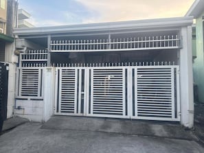 Una entrada cerrada con puerta de garaje y un ventanal pequeño.