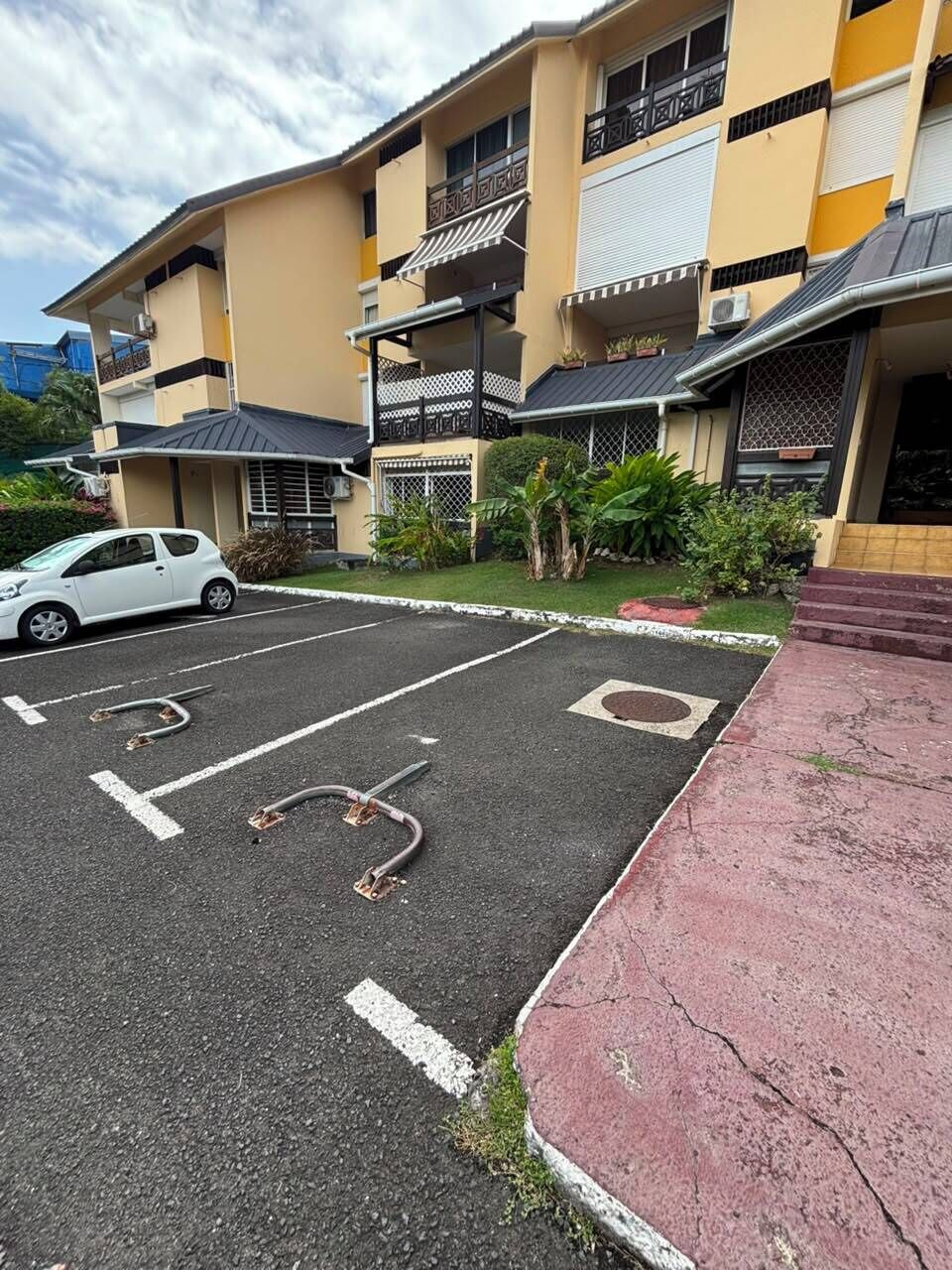 A multi-story residential building with a parking lot in front.