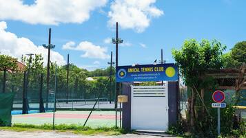 A tennis court with a sign for the Amical Tennis Club.