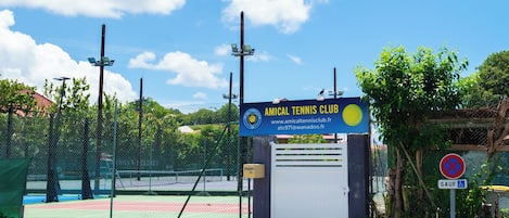 Una cancha de tenis con un cartel del Club de Tenis Amical.
