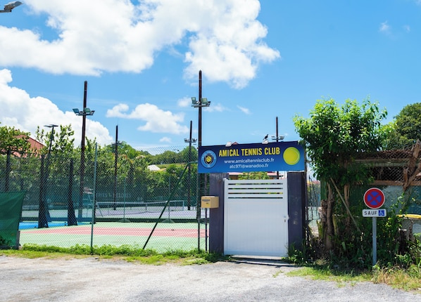 Una cancha de tenis con un cartel del Club de Tenis Amical.