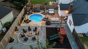 A backyard with a swimming pool, outdoor seating, and a play structure. - 4BR Backyard Oasis: Pool, Hot Tub & Fire Pit (Charlotte)