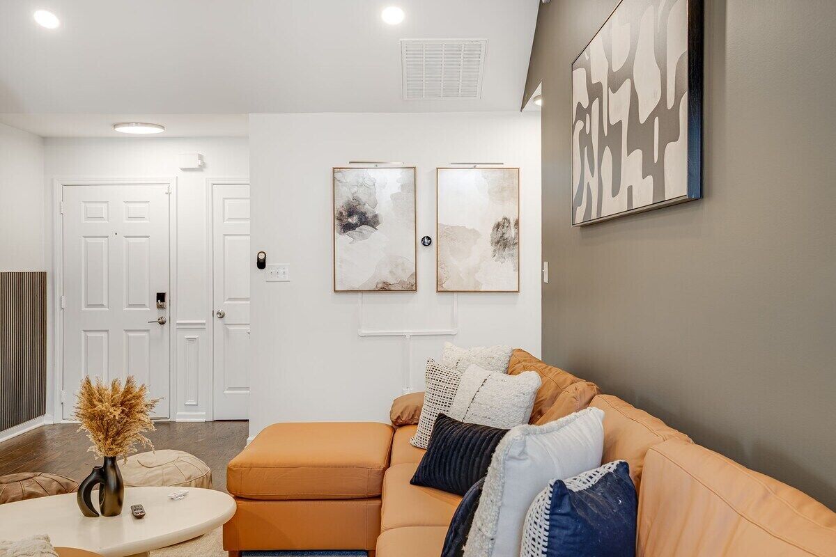A modern living room with a sectional sofa, a coffee table, and abstract wall art.