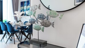 Un comedor moderno con una mesa redonda, sillas y una escultura decorativa de un pez.