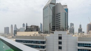 Un moderno edificio de gran altura con un diseño angular distintivo, rodeado de otros rascacielos en un paisaje urbano.