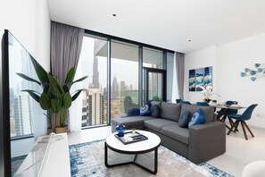 Een moderne woonkamer met een bank, salontafel en een eetgedeelte met stoelen en een tafel.
