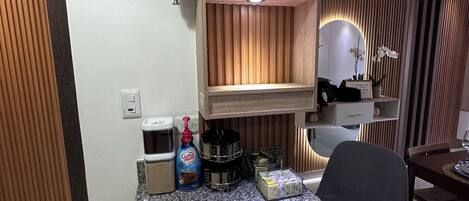 A kitchen area with granite countertops, wooden cabinets, and a built-in shelf unit.
