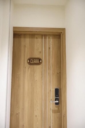 A wooden door with a nameplate reading 'CLARA' and a modern electronic lock. - D'la Lento Homestay (Hanoi)
