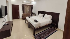 A modern bedroom with a bed, bedside tables, a TV, and a ceiling fan.