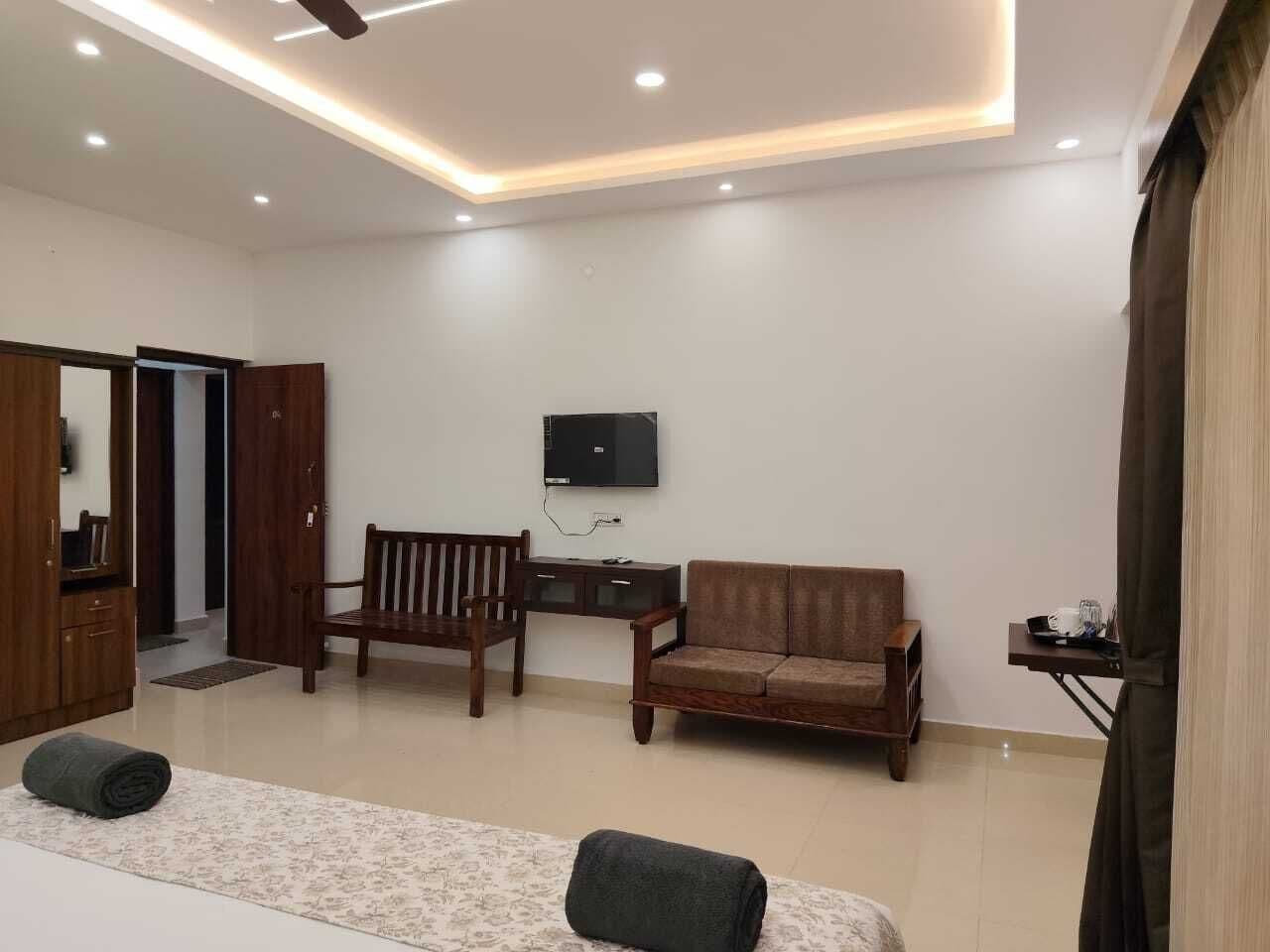 Una sala moderna con un sofá, una silla de madera, un televisor de pantalla plana montado en la pared y una mesita con una bandeja.