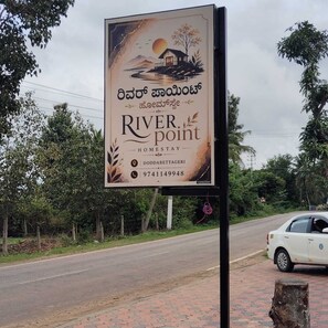 A signboard for a property named 'River Point' with contact details and a scenic illustration.