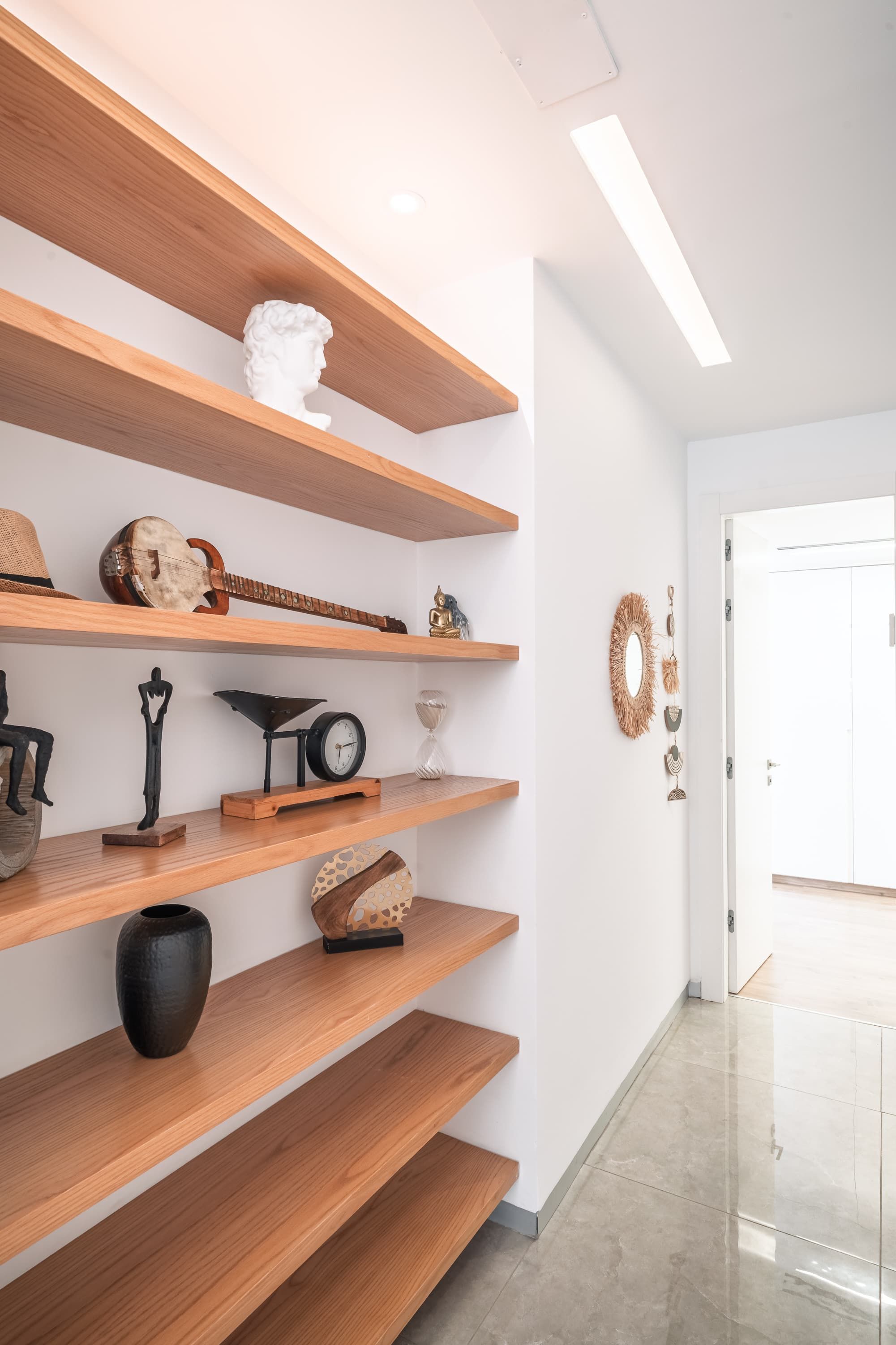 A modern interior with wooden shelves displaying various decorative items.