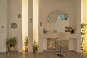 Casa de banho moderna com um espelho grande, um relógio e uma bancada com uma cadeira.