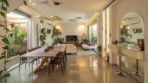 Un interior moderno con zona de comedor, asientos y televisor.