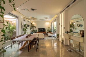 Um interior moderno com área de refeições, assentos e uma TV.