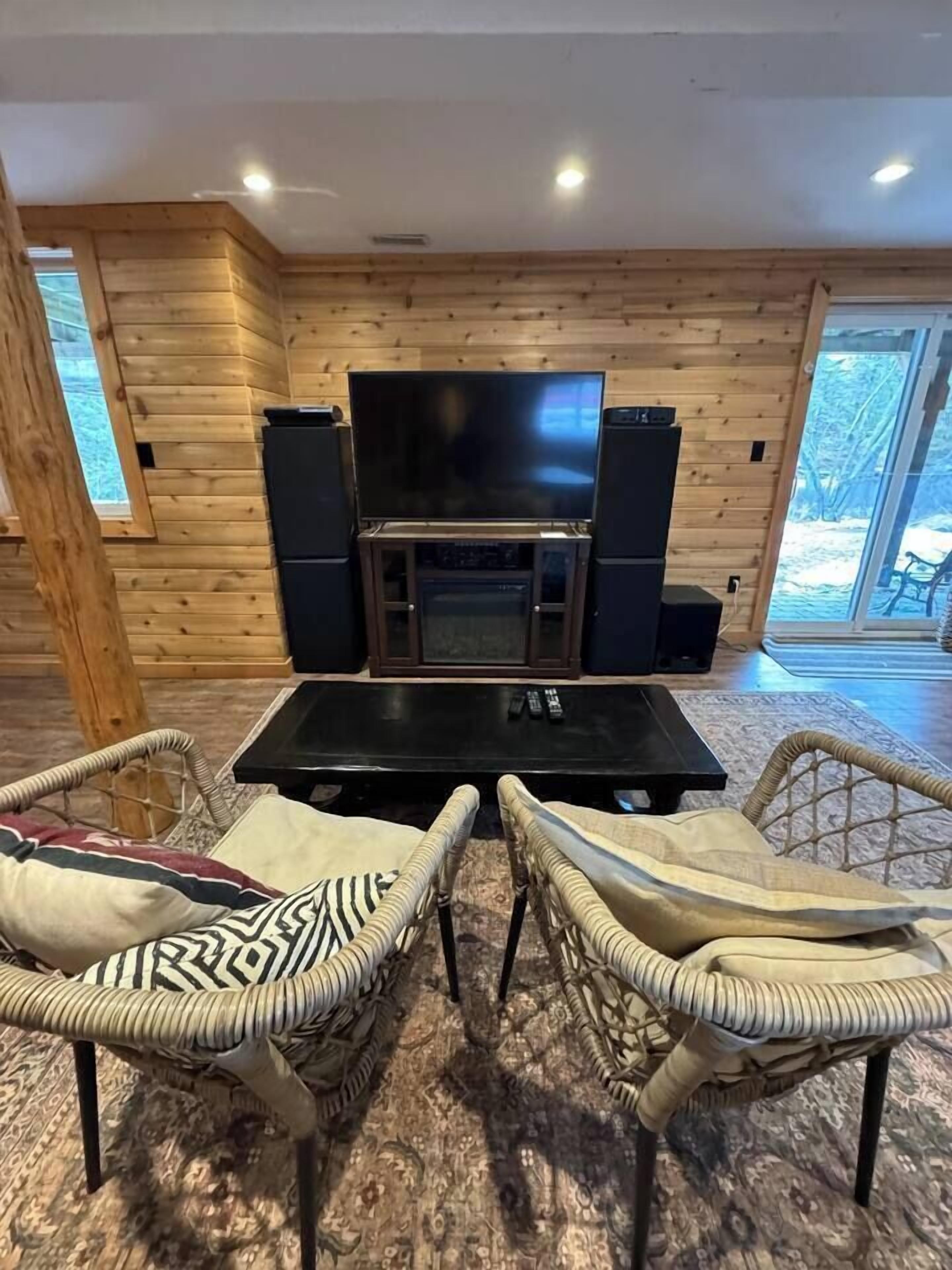 A cozy living area with a fireplace, a television, and wicker furniture.
