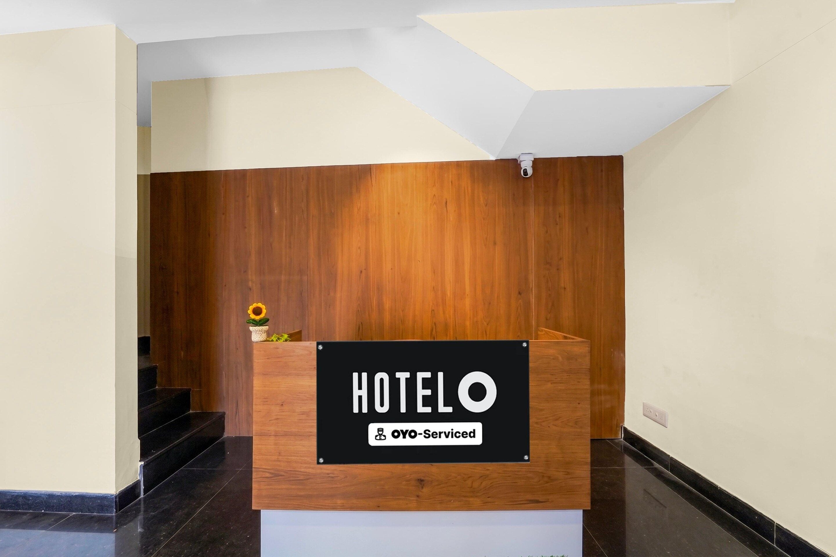 A hotel reception desk with a sign indicating it is serviced by OYO.