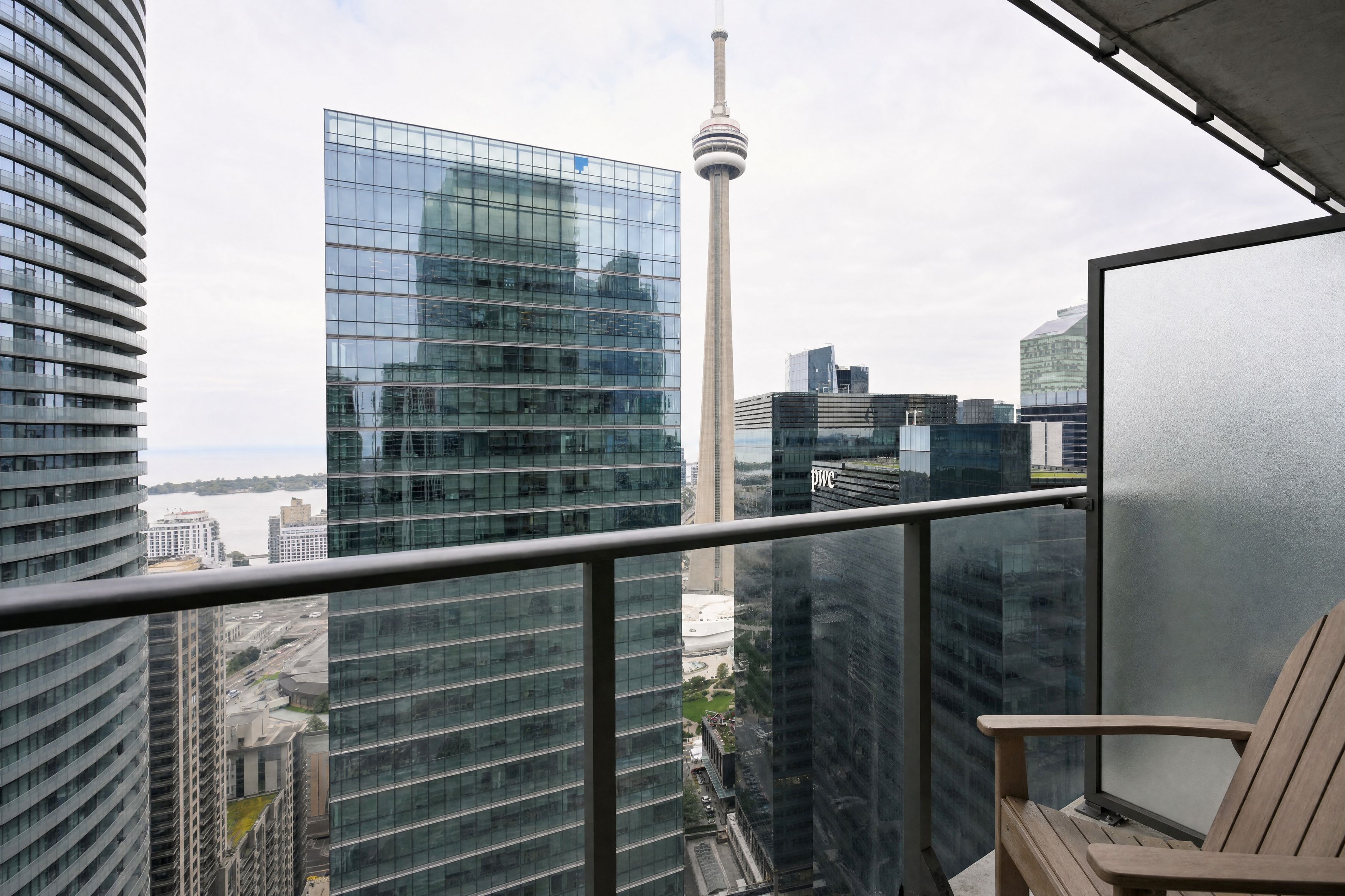 A high-rise building with a glass facade, a prominent tower, and a view of the cityscape.