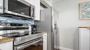 A kitchen with a built-in oven, microwave, and refrigerator. - Beachfront Oasis at Edgewater Resort in Panama City Beach (Panama City)