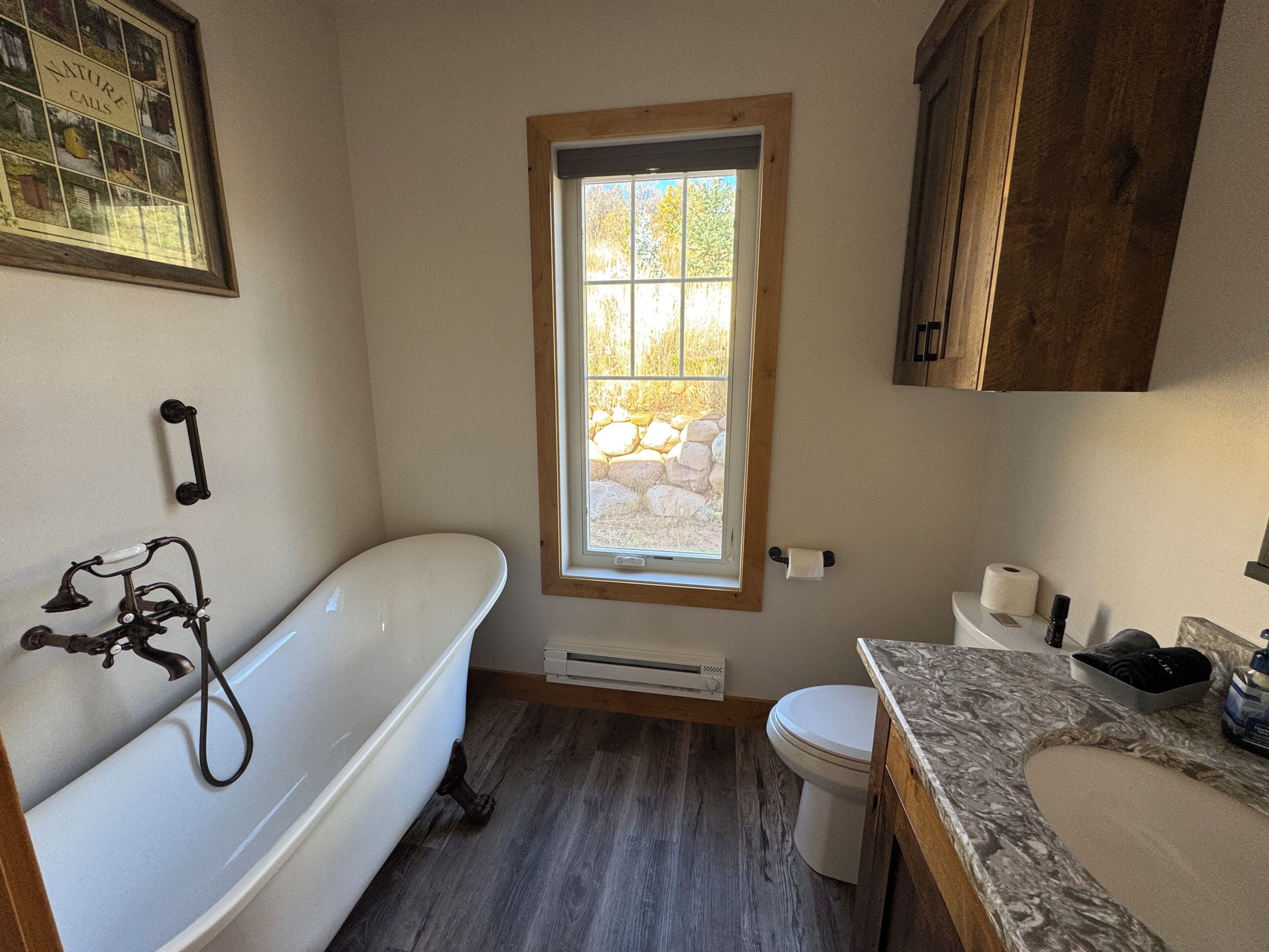 Une salle de bain équipée d’une baignoire, de toilettes et d’une fenêtre donnant sur l’extérieur.
