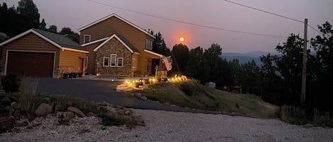 A house with a driveway, a garage, and a front yard with a small American flag.